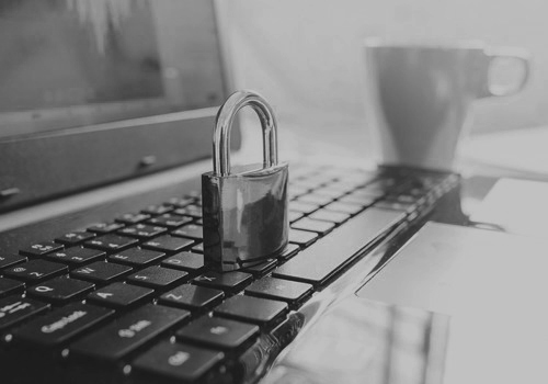 a padlock on top of a laptop's keyboard to represent vulnerability management assessment